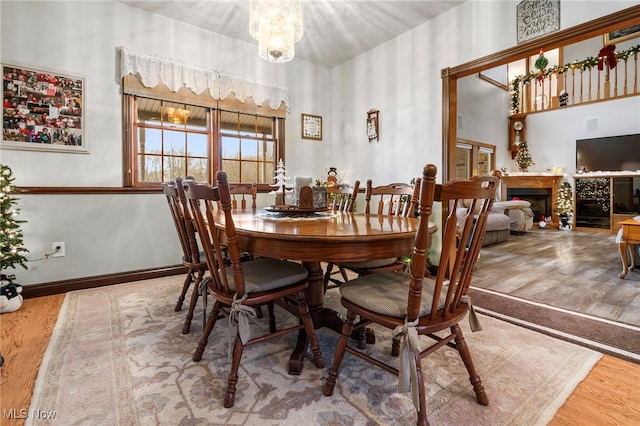 dining area with wood-type flooring and an inviting chandelier