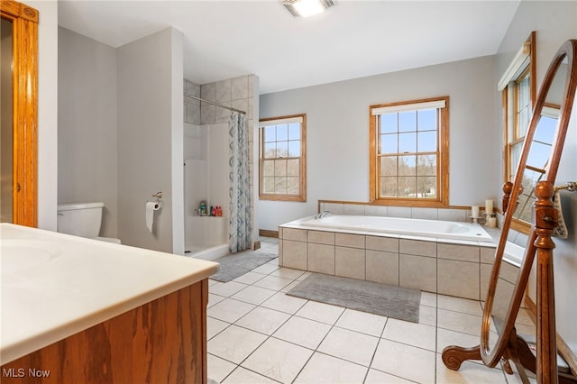 full bathroom featuring tile patterned flooring, vanity, shower with separate bathtub, and toilet