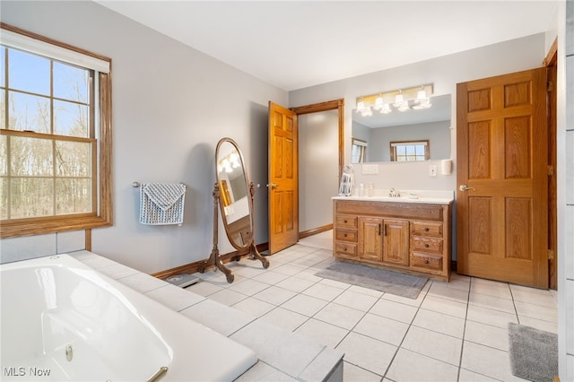 bathroom with a bath, vanity, and tile patterned floors