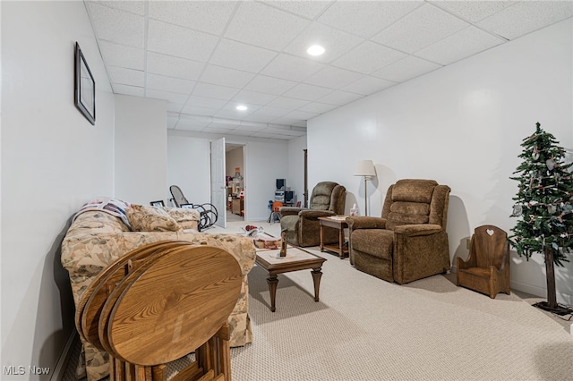 carpeted living room with a drop ceiling