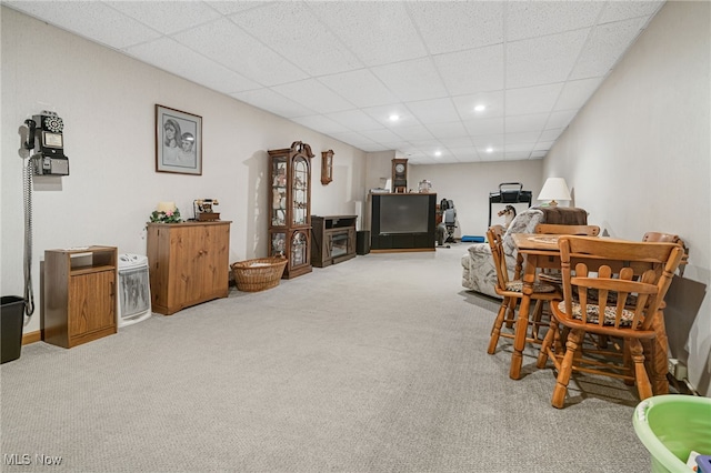 carpeted dining area with a drop ceiling