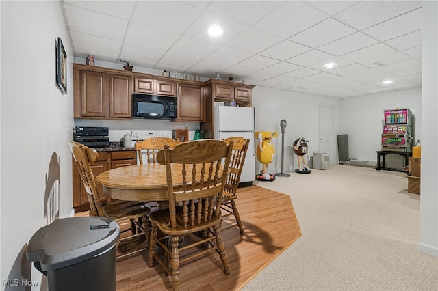 dining area with a paneled ceiling and wood-type flooring