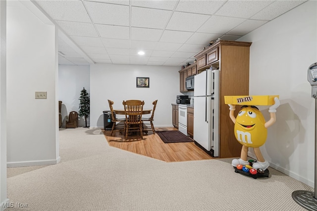 kitchen featuring a drop ceiling, wood-type flooring, and white appliances