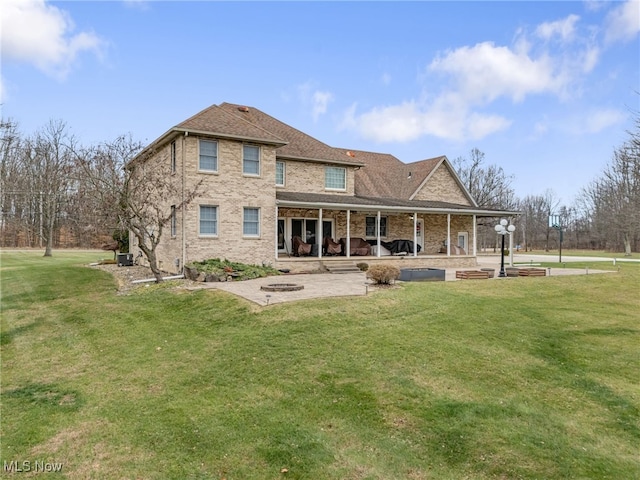 rear view of house with a lawn and a patio