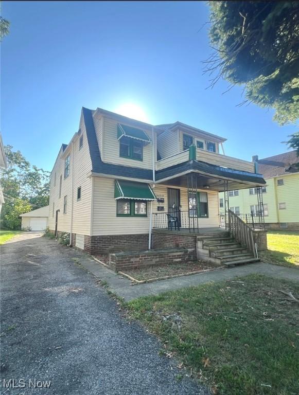 view of front of house featuring an outbuilding, a porch, and a garage