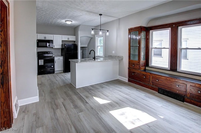 kitchen with white cabinetry, kitchen peninsula, light hardwood / wood-style floors, a textured ceiling, and black appliances