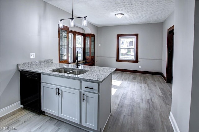 kitchen with white cabinets, dishwasher, plenty of natural light, and kitchen peninsula