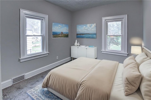 bedroom with carpet and a textured ceiling