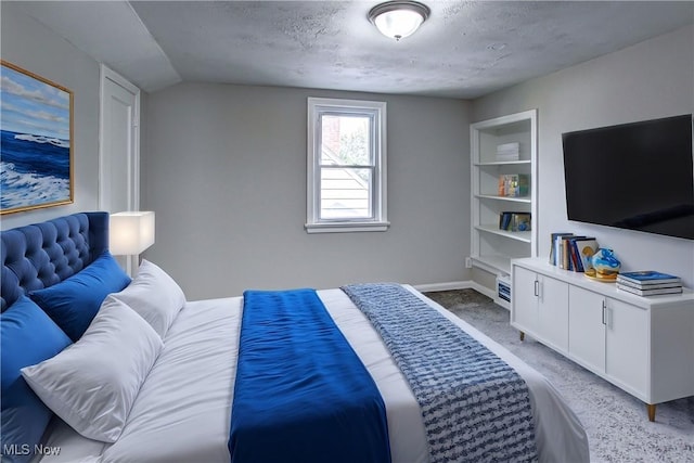 bedroom featuring vaulted ceiling and a textured ceiling