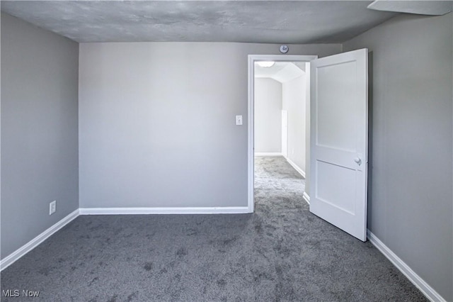 empty room with carpet flooring and a textured ceiling