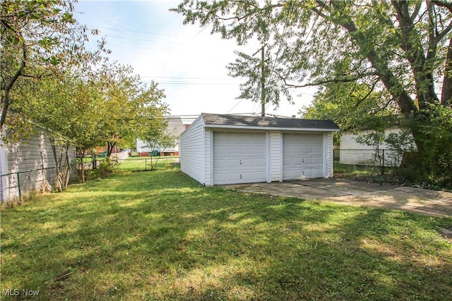 view of yard with a garage and an outbuilding