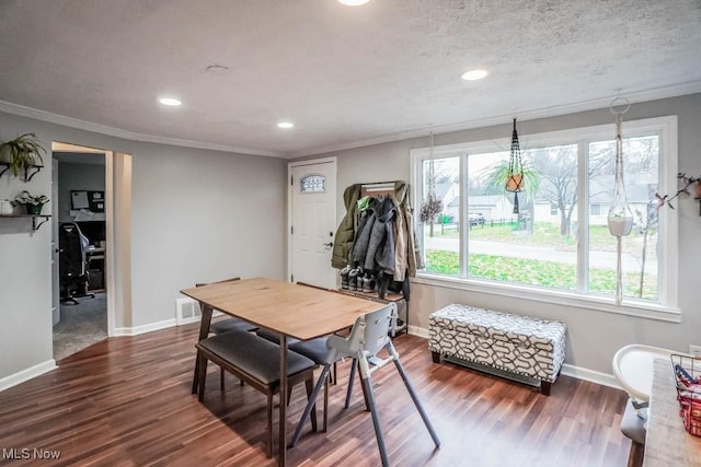 dining area featuring a textured ceiling, hardwood / wood-style flooring, and ornamental molding