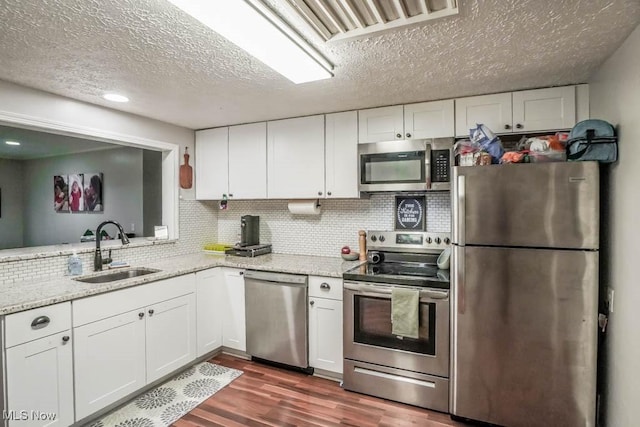 kitchen featuring stainless steel appliances, white cabinetry, and sink