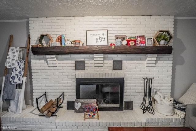 details featuring a textured ceiling, a brick fireplace, and crown molding