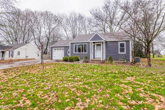 ranch-style home with central AC, a garage, and a front lawn