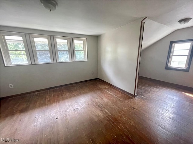 empty room with dark hardwood / wood-style floors and vaulted ceiling