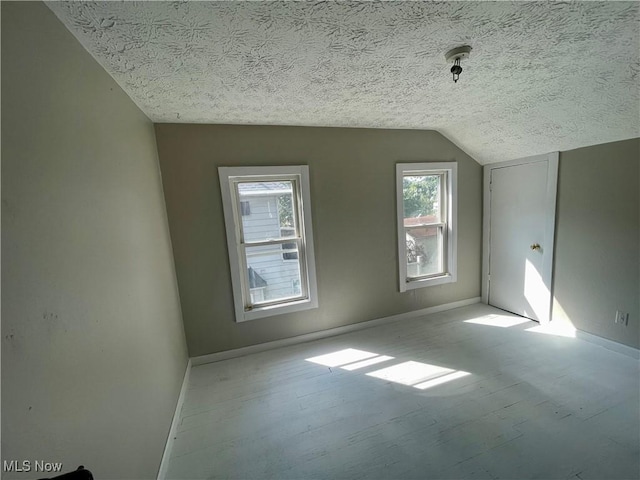 bonus room with a textured ceiling and vaulted ceiling