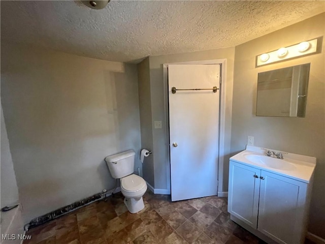 bathroom with vanity, a textured ceiling, and toilet