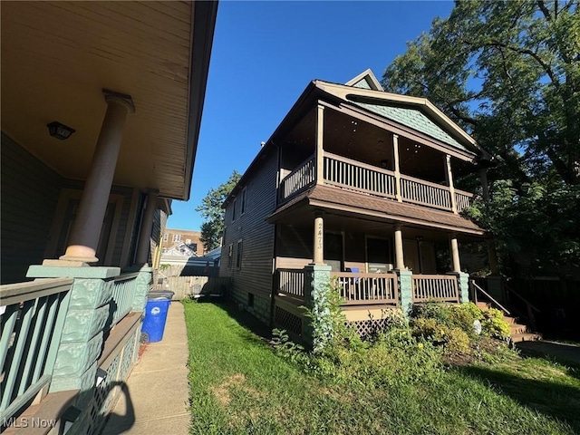 view of front of property with a balcony, a front lawn, and covered porch