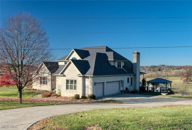 view of front facade featuring a gazebo, a garage, and a front lawn