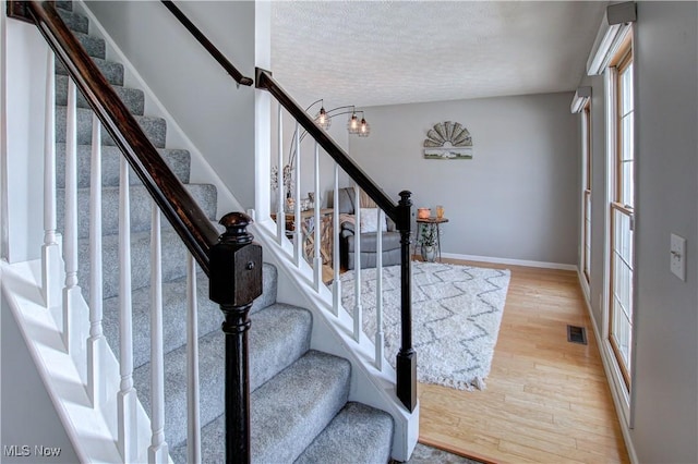 foyer entrance featuring light hardwood / wood-style floors and a textured ceiling