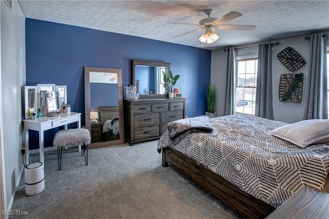 bedroom featuring a textured ceiling, ceiling fan, and light carpet