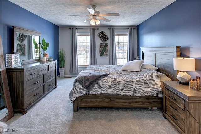 carpeted bedroom featuring ceiling fan and a textured ceiling