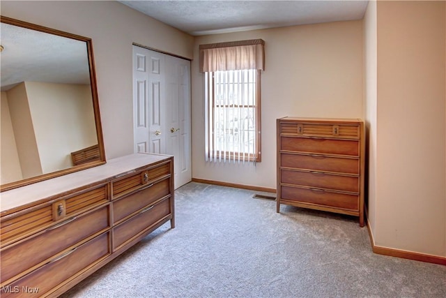 carpeted bedroom with a textured ceiling and a closet