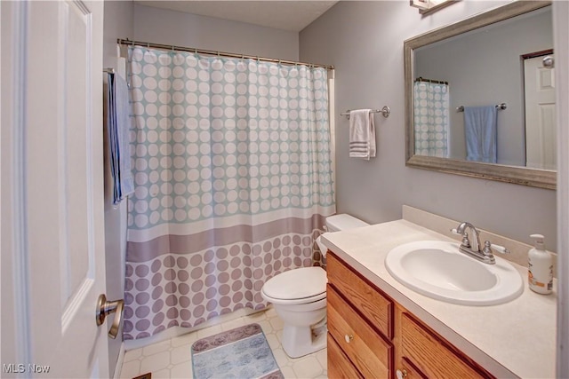 bathroom featuring curtained shower, vanity, and toilet