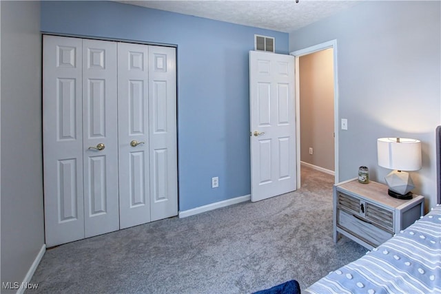 bedroom featuring a closet, carpet, and a textured ceiling