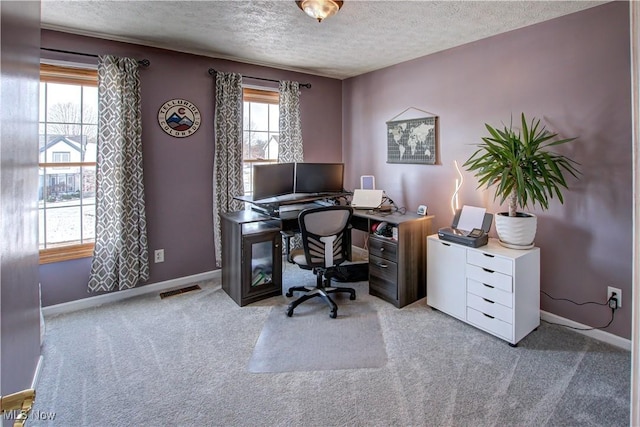 carpeted office featuring a textured ceiling