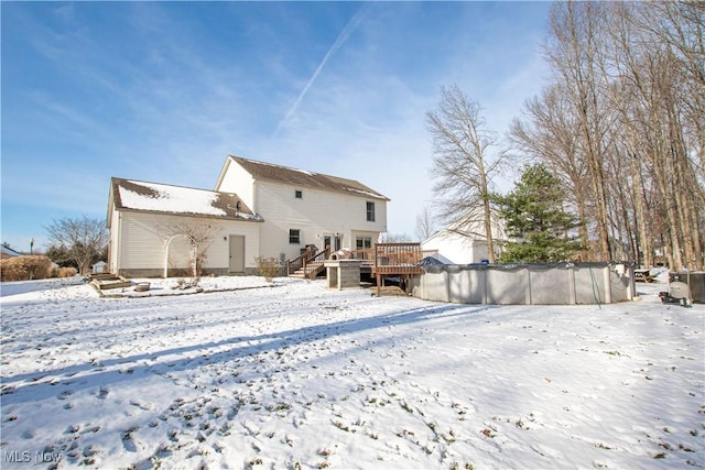 snow covered house with a wooden deck