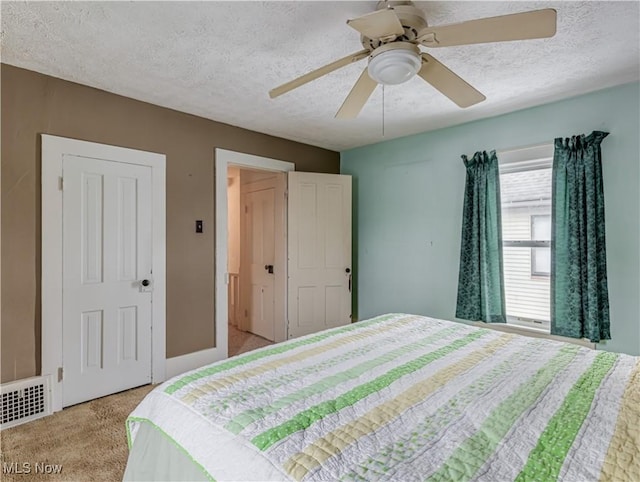 bedroom featuring ceiling fan, light colored carpet, a textured ceiling, and a closet