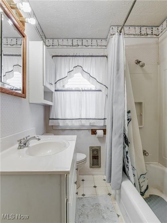 full bathroom featuring tile patterned flooring, shower / bath combination with curtain, a textured ceiling, toilet, and vanity