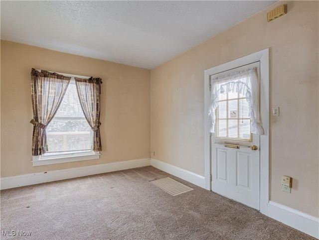 entrance foyer with carpet and a textured ceiling