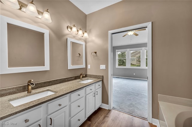 bathroom with hardwood / wood-style floors, vanity, ceiling fan, and a bathing tub