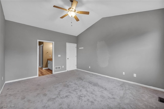 unfurnished bedroom with ensuite bathroom, light colored carpet, vaulted ceiling, ceiling fan, and a closet