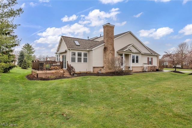 rear view of property featuring a lawn and a deck