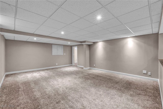 basement featuring a drop ceiling and carpet