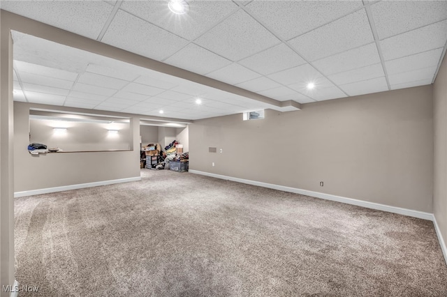 basement featuring a drop ceiling and carpet floors