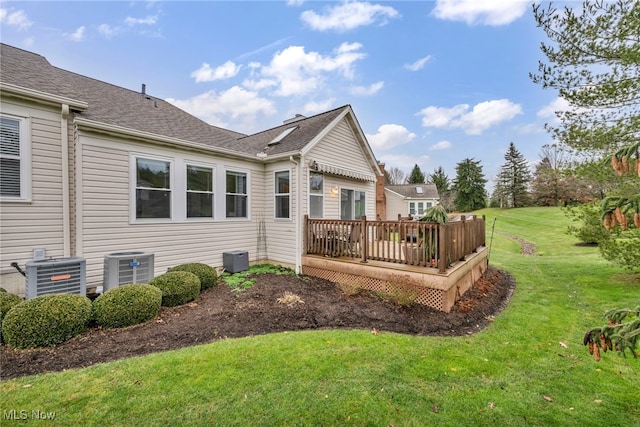 rear view of property featuring central air condition unit, a yard, and a deck