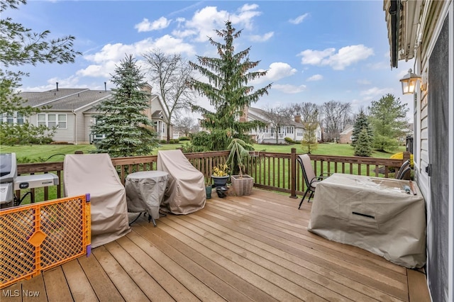 deck featuring a grill and a yard