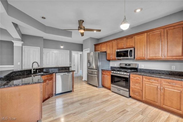 kitchen featuring pendant lighting, sink, light hardwood / wood-style flooring, ceiling fan, and appliances with stainless steel finishes