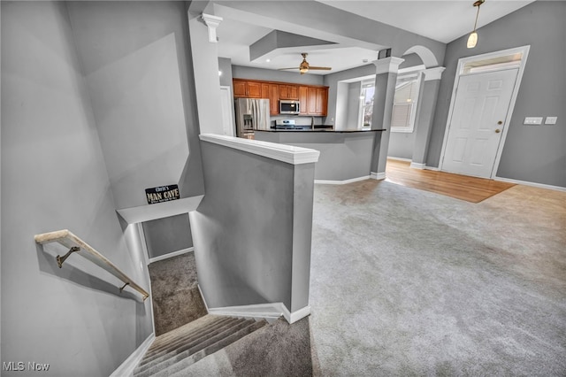 kitchen featuring kitchen peninsula, light carpet, a breakfast bar, stainless steel appliances, and vaulted ceiling