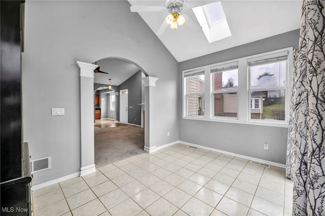 tiled spare room featuring vaulted ceiling, ceiling fan, and ornate columns