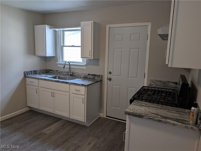 kitchen with black range oven, exhaust hood, sink, dark hardwood / wood-style floors, and white cabinetry