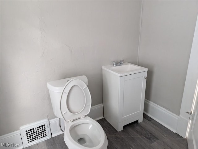 bathroom featuring vanity, hardwood / wood-style flooring, and toilet