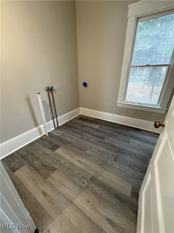 clothes washing area with a wealth of natural light and dark wood-type flooring