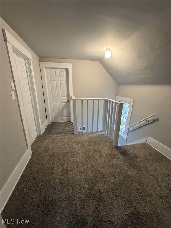 staircase with carpet floors and vaulted ceiling