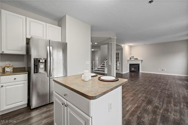 kitchen with white cabinets, stainless steel fridge, and dark wood-type flooring